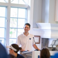 GV Employee smiles as he looks into crowd while standing at podium